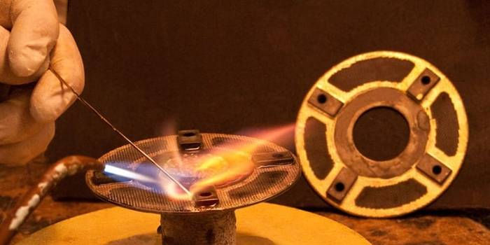 The worker is brazing metal part.