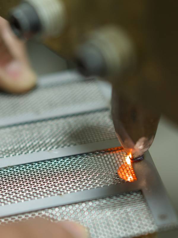 The worker is welding the filter element by using resistance welding method.