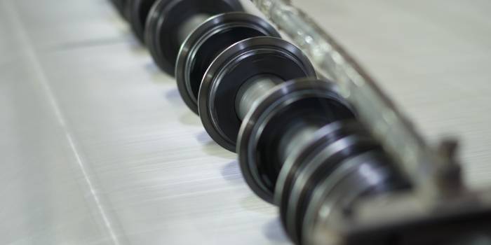 The rotary blades are slitting the wire cloth into strips.